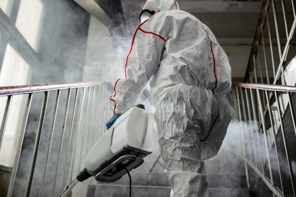 Male in an NBC personal protective equipment treating a staircase